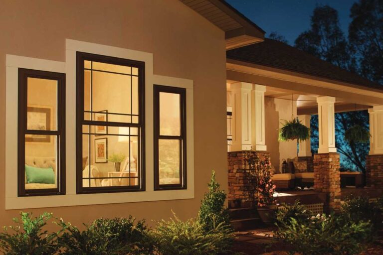 Overland Park home exterior featuring dark-framed vinyl replacement windows at dusk
